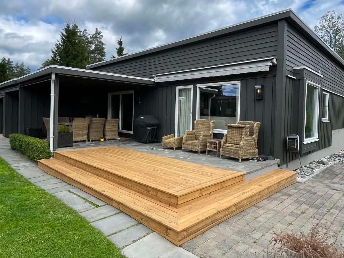Ny treterrasse ved en mørk enebolig